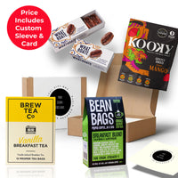 The Morning Hit gift box featuring Raw Bean coffee bags, Brew Tea Co vanilla breakfast tea, and What a Date pecan snacks, presented in a sustainable kraft box with eco sizzle pack and branded sleeve thumbnail